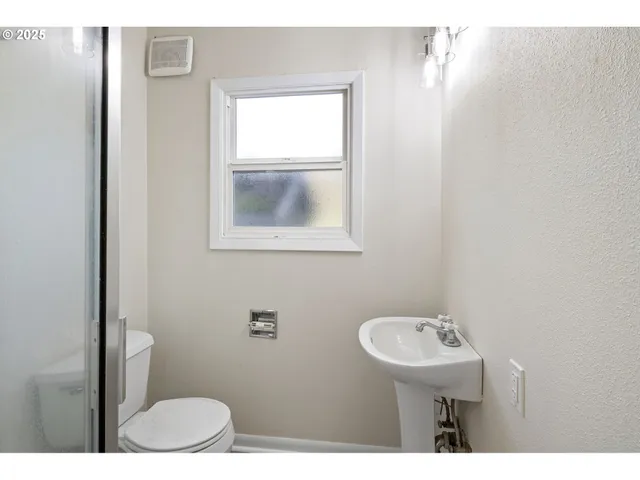 a bathroom with a toilet a sink and mirror
