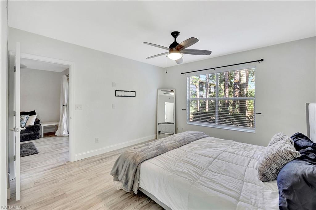 1965 Courtyard Way, Unit E106 Naples, FL 34112 - Photo 13 of 25 Bedroom with light wood finished floors, baseboards, and ceiling fan