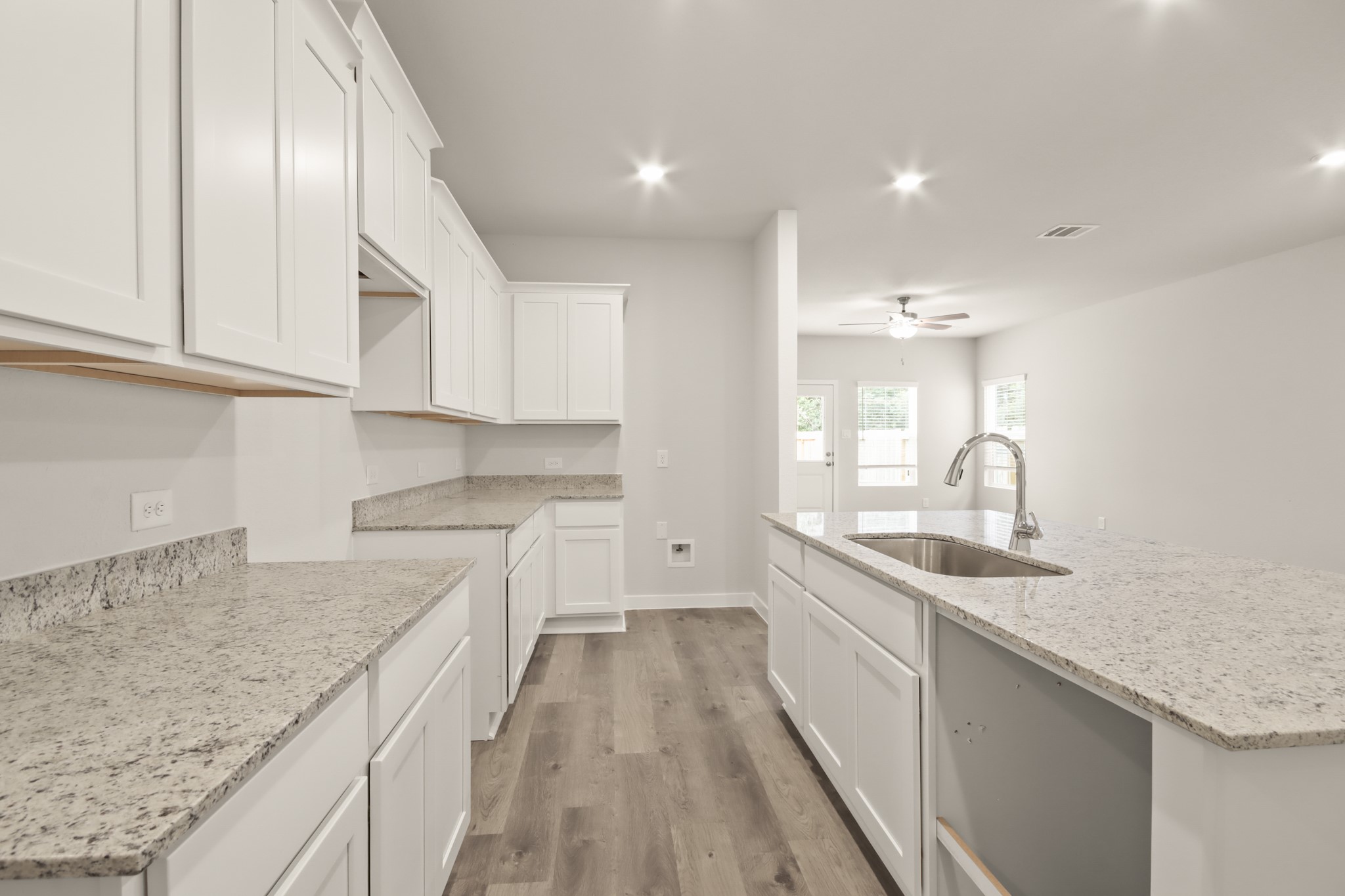 16922 Needlepoint Drive Conroe, TX 77302 - Photo 10 of 31 a kitchen with granite countertop a sink stainless steel appliances and white cabinets
