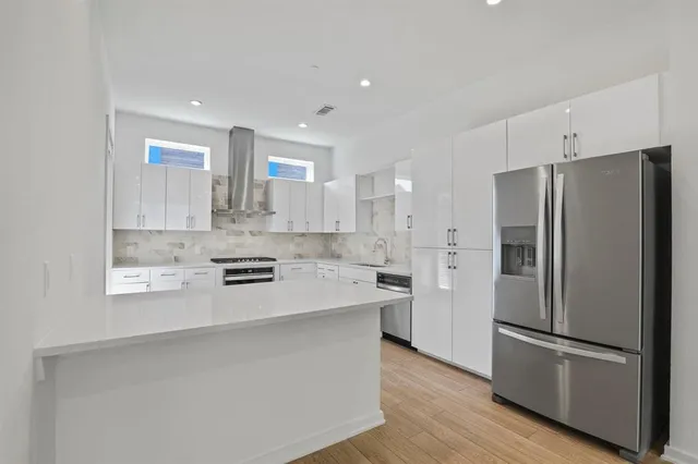 a kitchen with stainless steel appliances a refrigerator sink and microwave