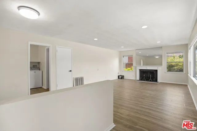 a view of an empty room with a fireplace and a window
