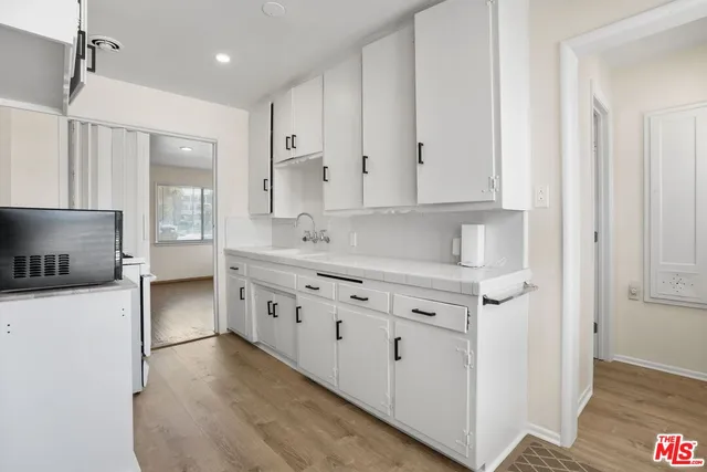 a kitchen with stainless steel appliances white cabinets and a refrigerator