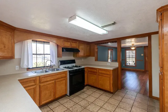 a kitchen with stainless steel appliances granite countertop a stove a sink and a microwave