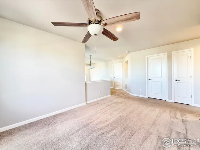 a view of an empty room with a ceiling fan