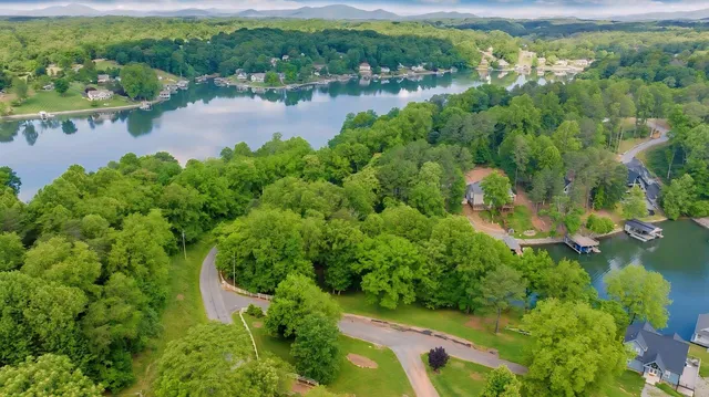 an aerial view of lake residential house with outdoor space and trees all around