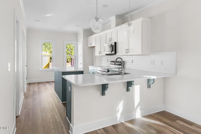 a kitchen with stainless steel appliances granite countertop a sink stove and wooden floor