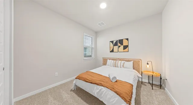 a bedroom with a bed and a painting on the wall