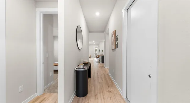 a view of a hallway with wooden floor and entryway