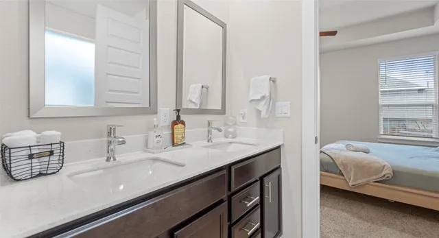 a en suite bathroom with a granite countertop sink and a mirror