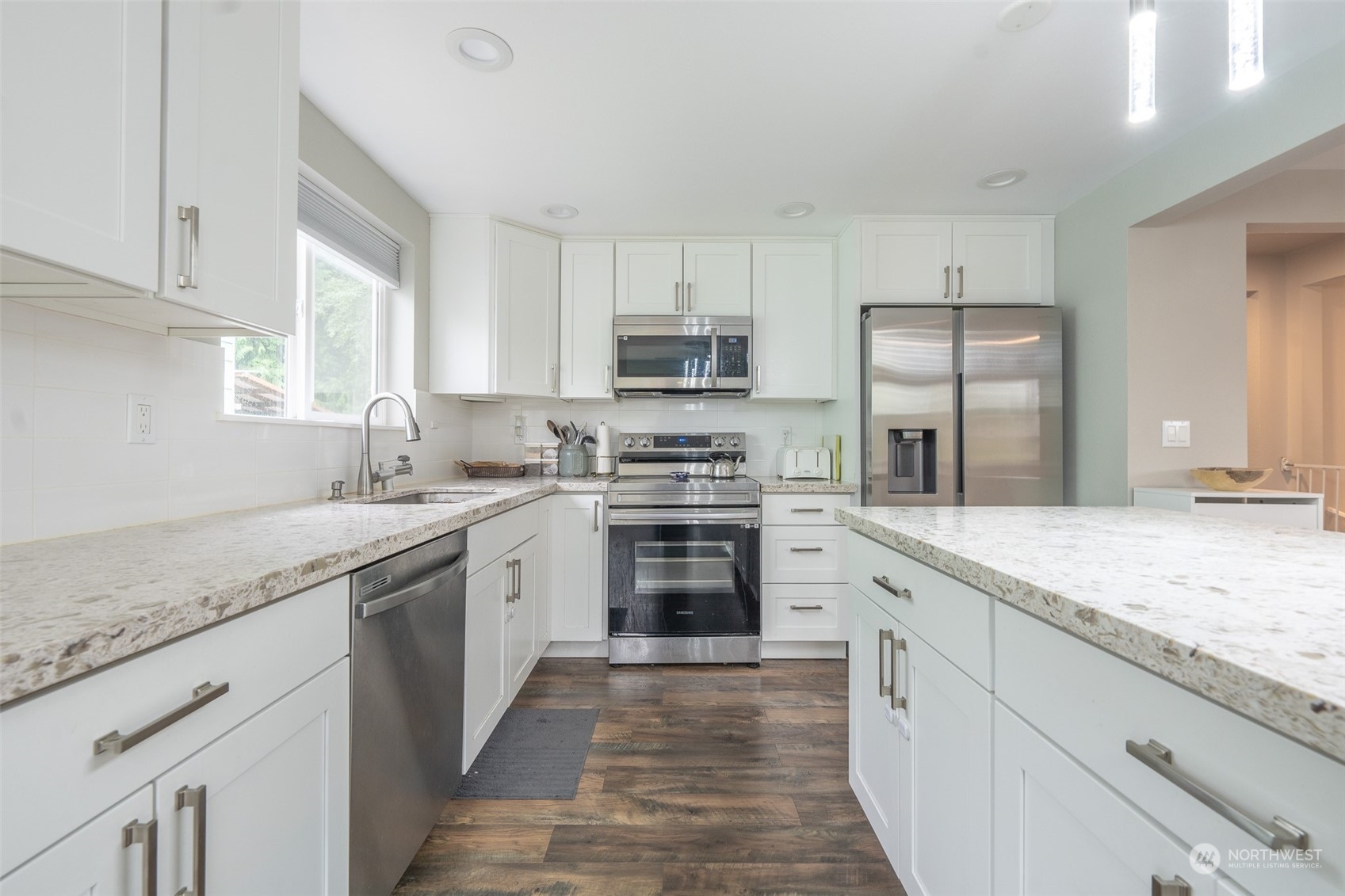 5515 South Bangor Street Seattle, WA 98178 - Photo 9 of 33 a kitchen with granite countertop a sink stainless steel appliances and white cabinets