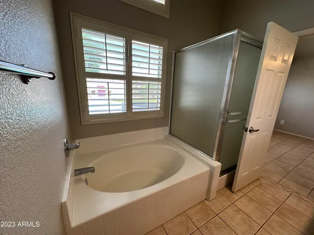 a white bath tub sitting in a bathroom next to a window