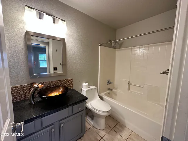 a bathroom with a granite countertop sink a toilet and shower