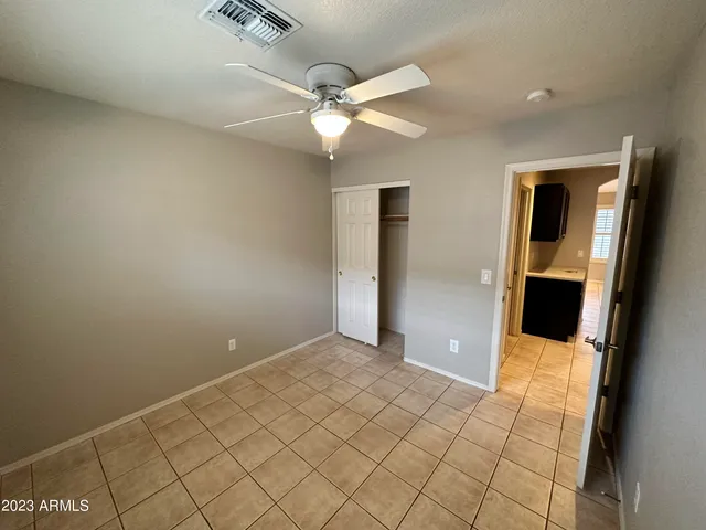 an empty room with fan and entrance