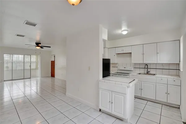 a kitchen with a stove sink and cabinets