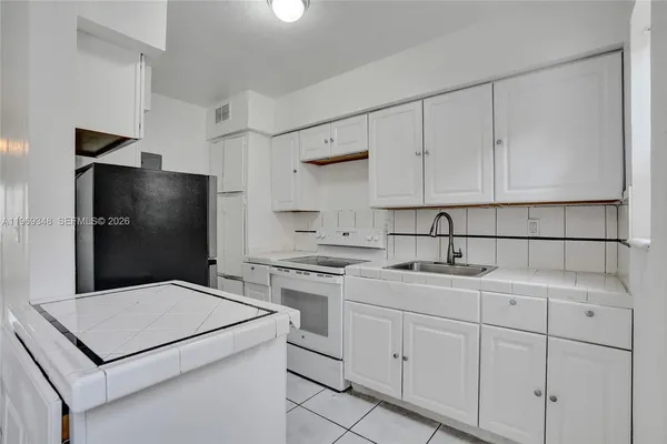 a white refrigerator freezer and a wooden floor