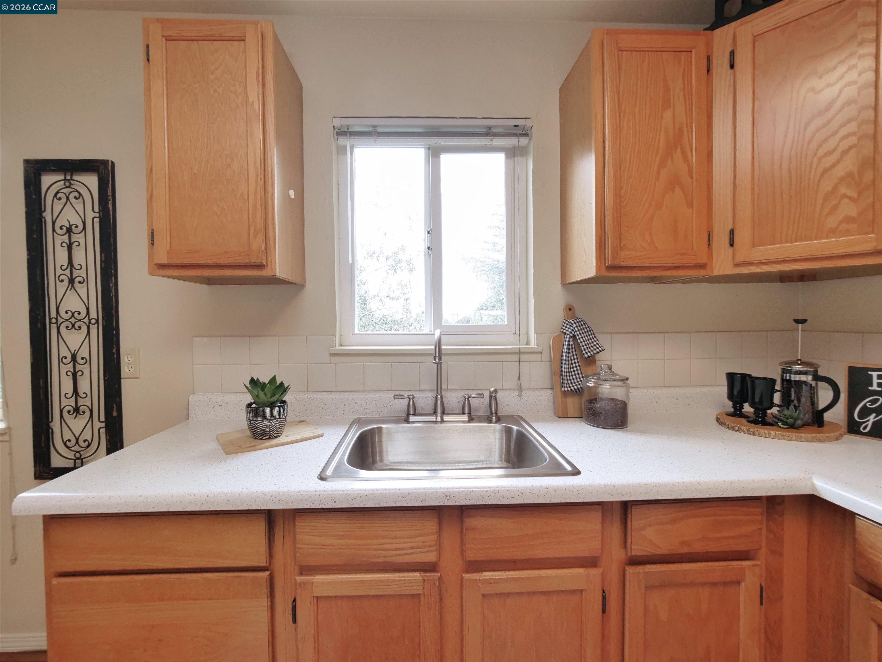 995 Virginia Street Berkeley, CA 94710 - Photo 26 of 59 a kitchen with white cabinets and a sink