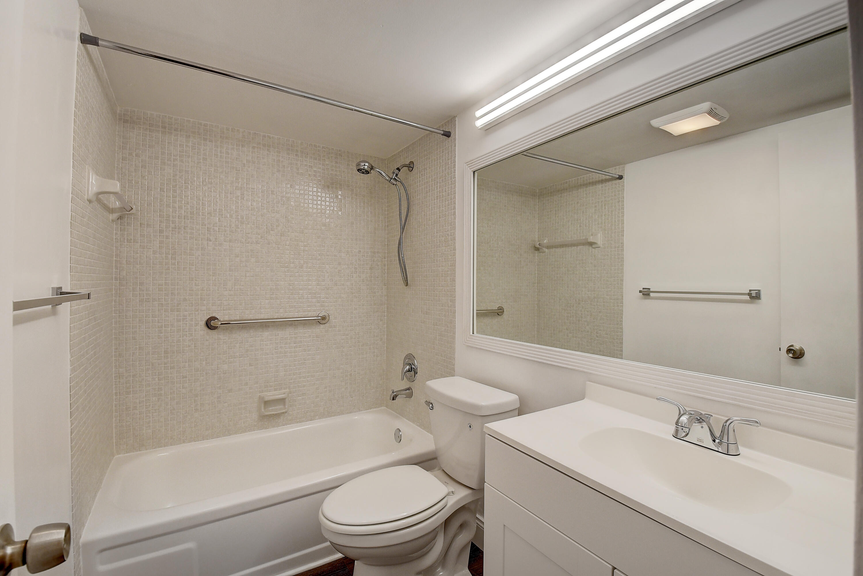 49 Suffolk B, Unit 49 Boca Raton, FL 33434 - Photo 11 of 47 a bathroom with a toilet a sink a mirror a bathtub and vanity