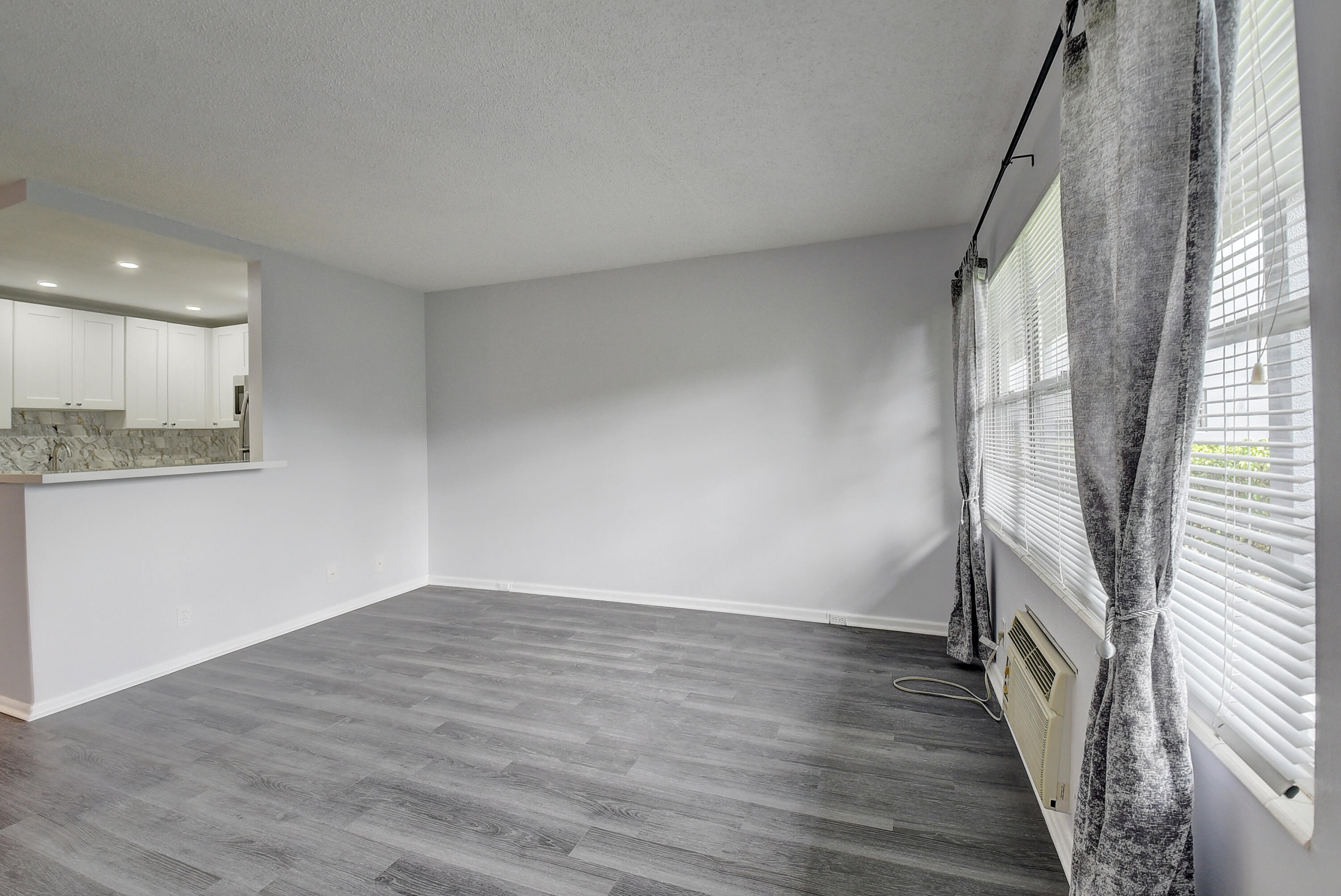 49 Suffolk B, Unit 49 Boca Raton, FL 33434 - Photo 6 of 47 a view of an empty room with wooden floor and a window