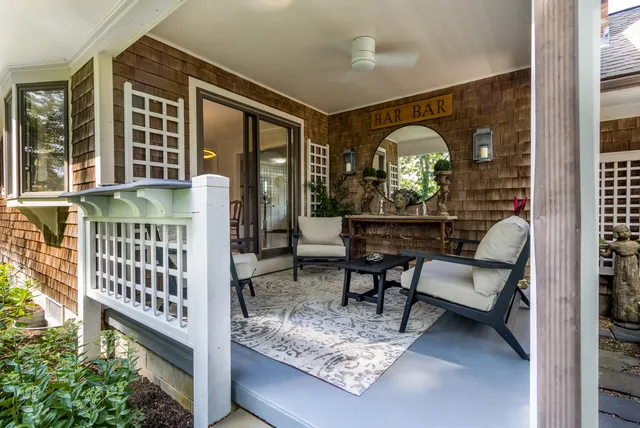 a view of a balcony with chairs and wooden floor