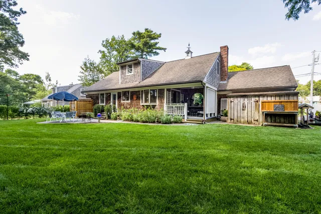a view of an house with backyard and outdoor seating