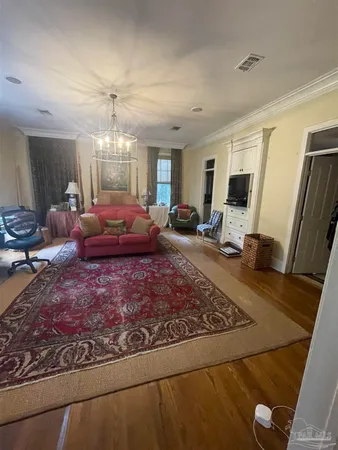 a living room with furniture hard wood floor and a rug