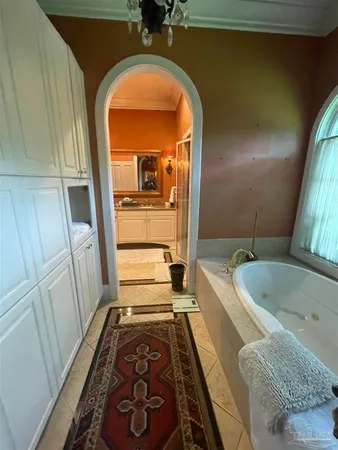 a bathroom with a tub sink and mirror