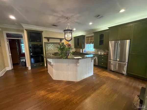a kitchen with stainless steel appliances granite countertop a refrigerator and a sink