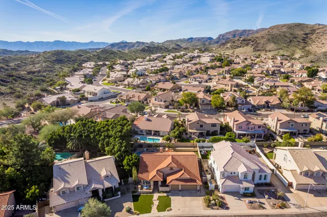 an aerial view of residential houses with outdoor space and trees