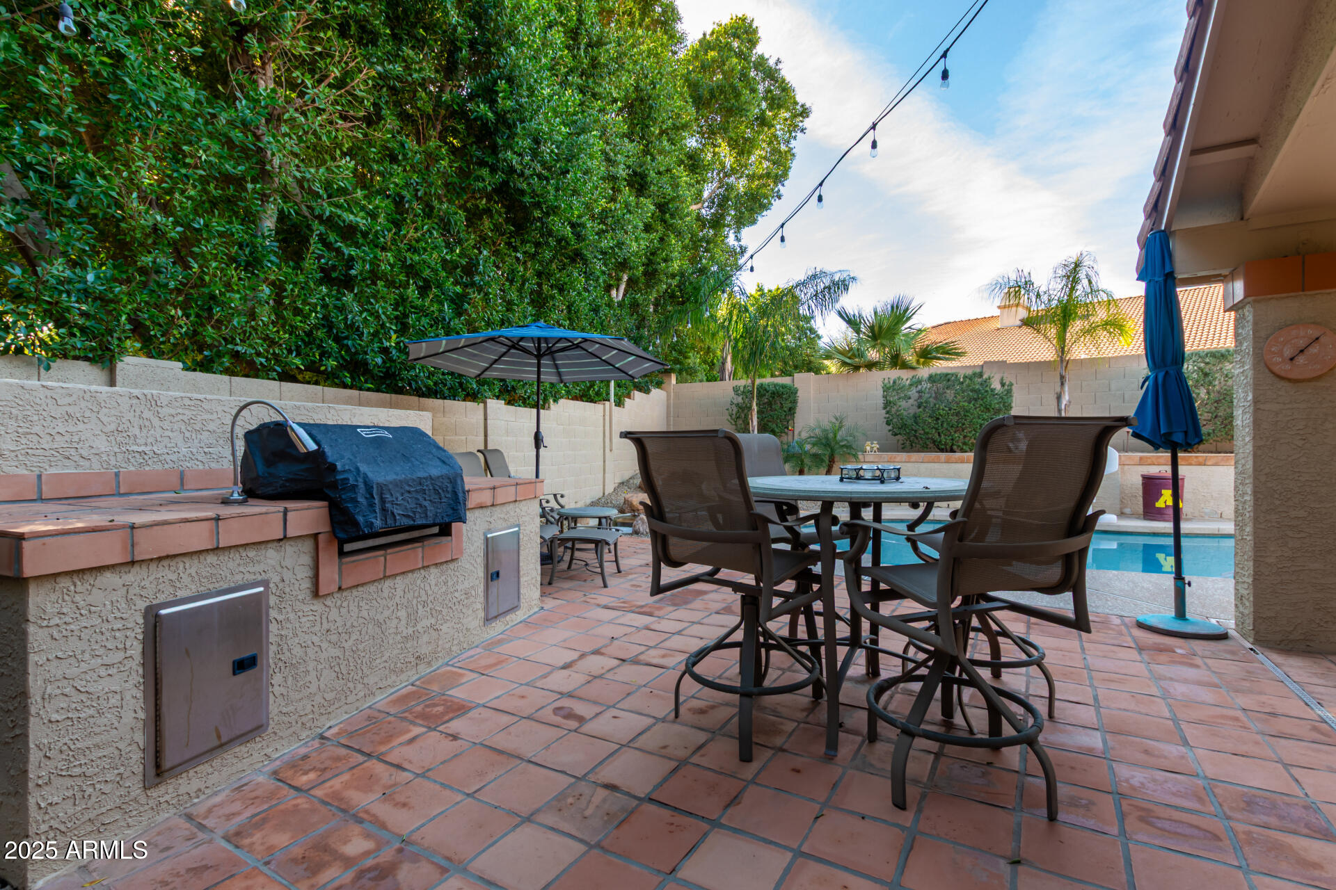 14044 South 33rd Way Phoenix, AZ 85044 - Photo 28 of 59 a view of a patio with a dining table and chairs under an umbrella with a barbeque