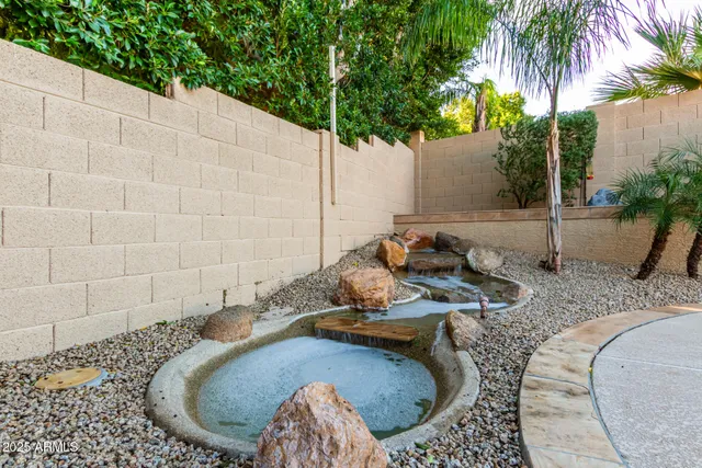 a view of a swimming pool with a patio and plants