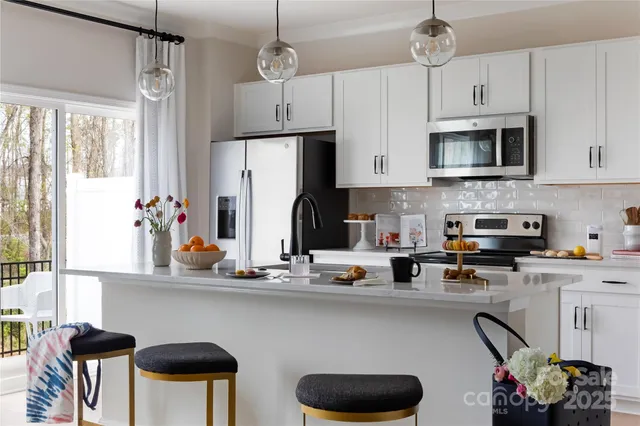 a kitchen with stainless steel appliances granite countertop a sink refrigerator and cabinets