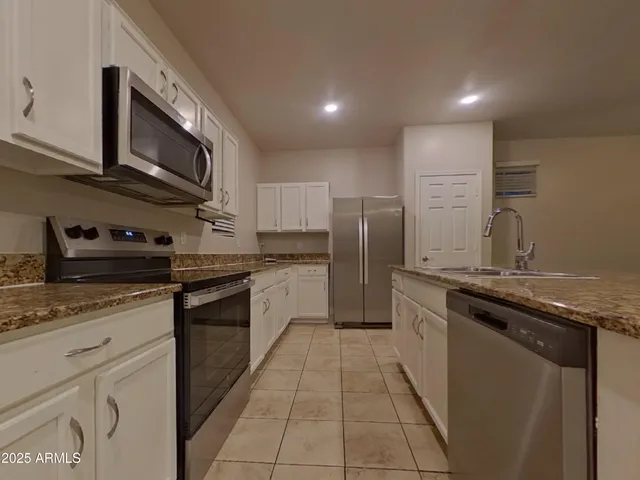 a kitchen with stainless steel appliances granite countertop a sink and a stove