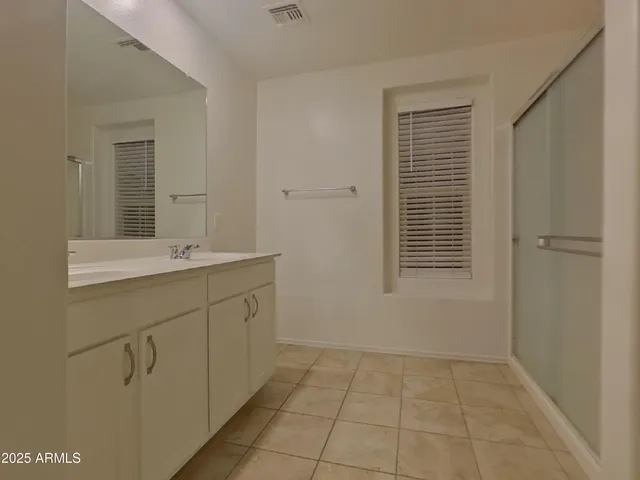 an empty room with a ceiling fan and window