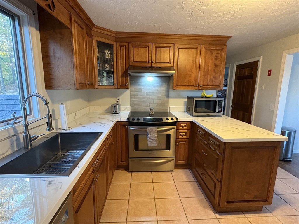 11 Potter Road Douglas, MA 01516 - Photo 16 of 41 a kitchen with a stove sink and cabinets