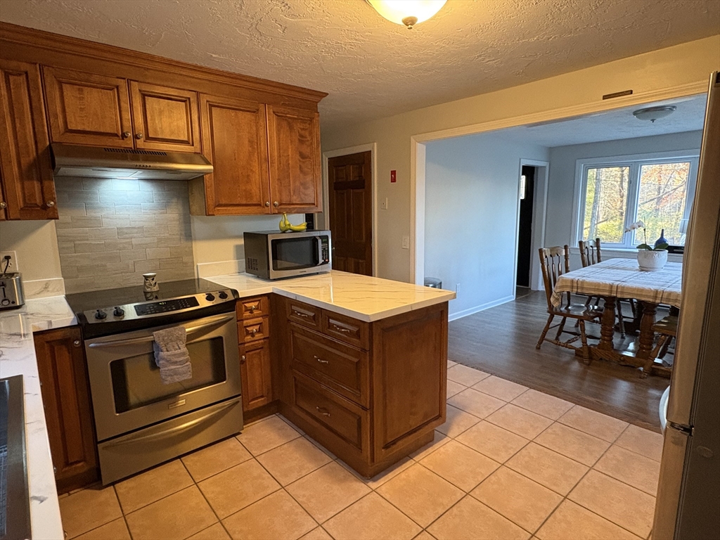 11 Potter Road Douglas, MA 01516 - Photo 17 of 41 a kitchen with stainless steel appliances granite countertop a stove a sink and a microwave