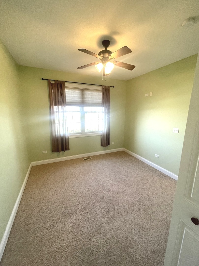 440 Edgebrook Drive Bourbonnais, IL 60914 - Photo 29 of 34 an empty room with windows and chandelier fan