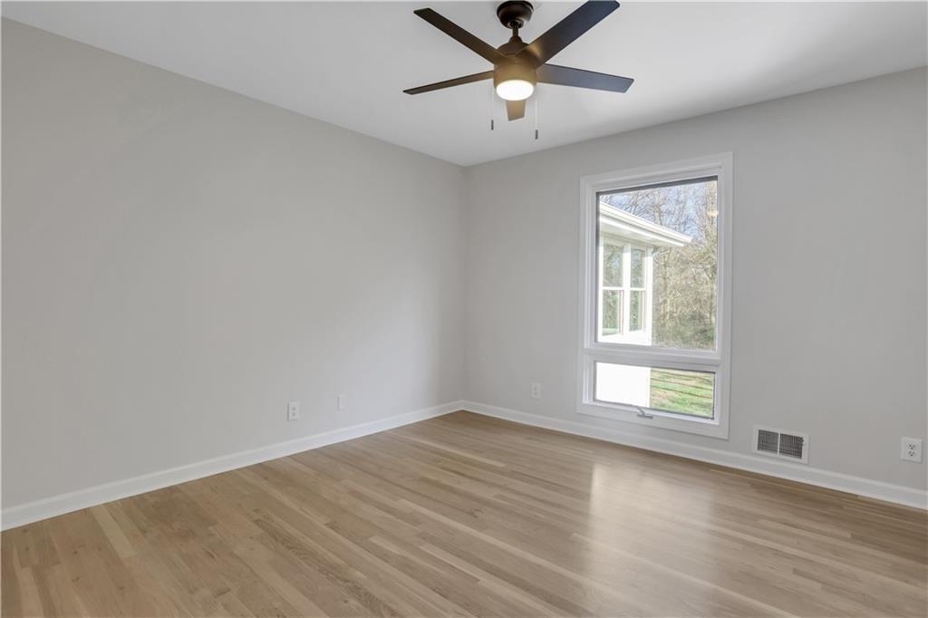 600 Rounsaville Road Roswell, GA 30076 - Photo 25 of 45 an empty room with wooden floor ceiling fan and windows