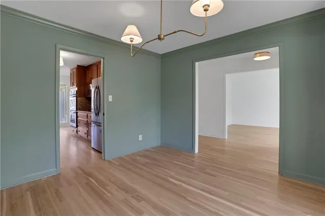a view of an empty room with wooden floor fireplace and a window