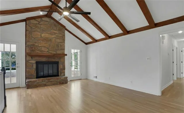 a view of empty room with wooden floor and floor to ceiling window