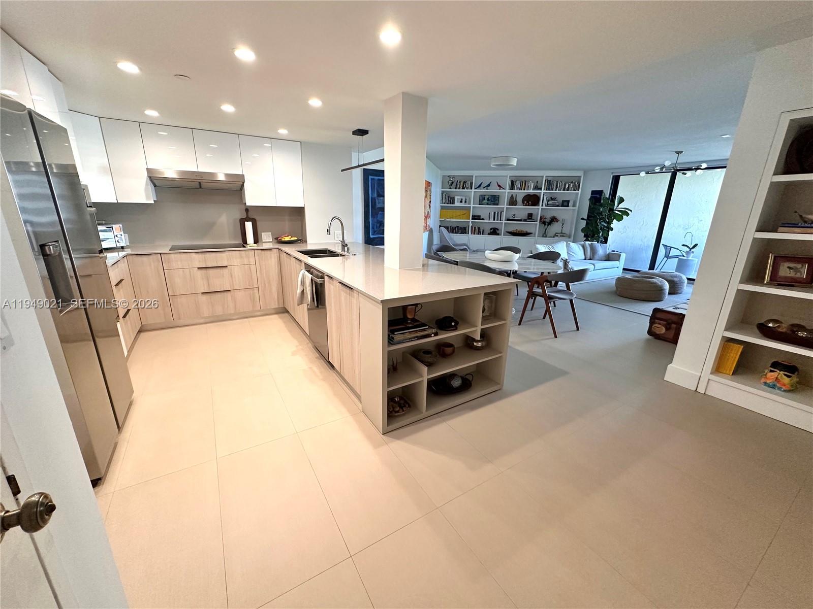 170 Ocean Ln Drive, Unit 809 Key Biscayne, FL 33149 - Photo 7 of 31 a large white kitchen with stainless steel appliances kitchen island granite countertop a refrigerator and a stove top oven