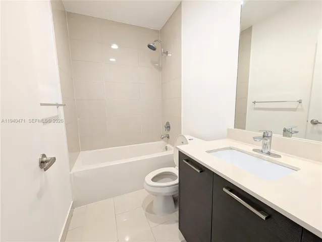 a bathroom with a granite countertop sink a toilet and bathtub