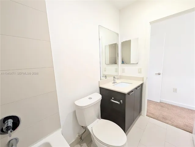 a bathroom with a sink vanity mirror and toilet