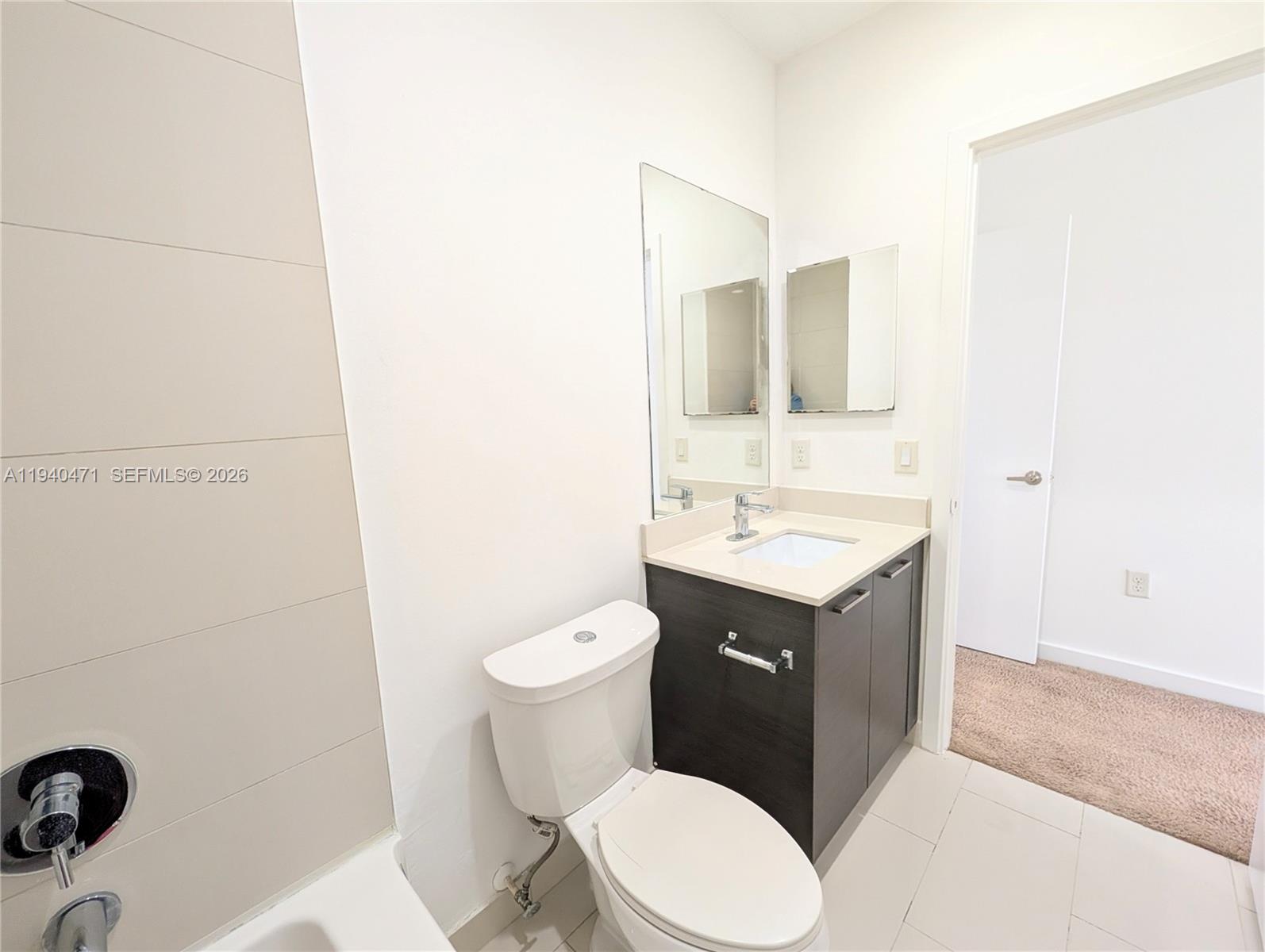 3484 Northwest 13th Street, Unit 3484 Lauderhill, FL 33311 - Photo 24 of 49 a bathroom with a sink vanity mirror and toilet