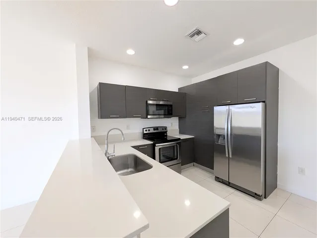 a kitchen with stainless steel appliances a refrigerator and a sink