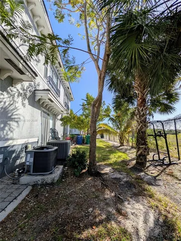 a backyard of a house with a garden and outdoor seating