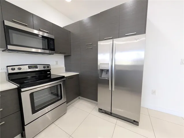 a kitchen with stainless steel appliances granite countertop a stove a microwave and a refrigerator