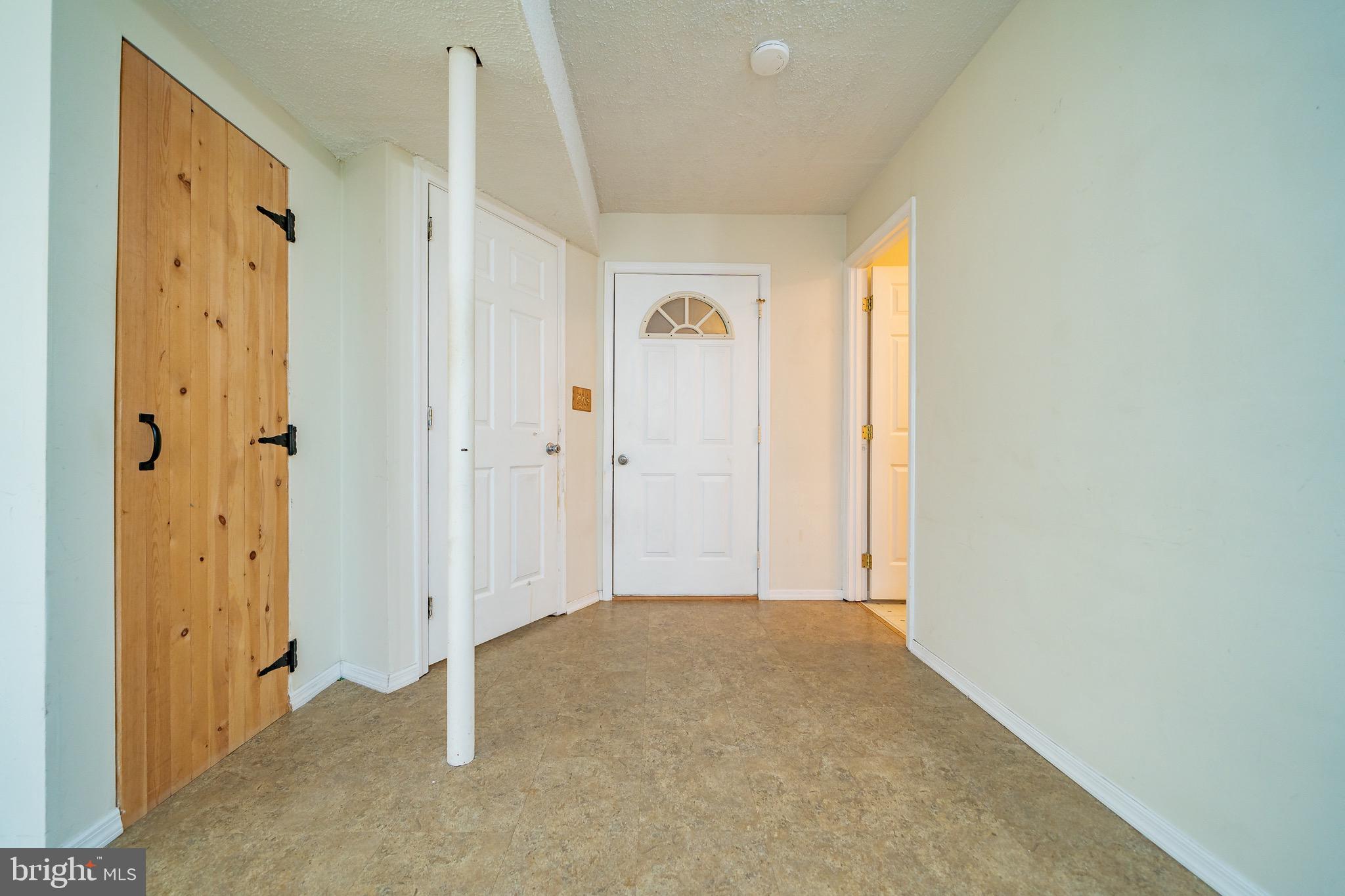 11109 Rawhide Road Lusby, MD 20657 - Photo 27 of 41 Door to garage & wooden door -storage under stairs
