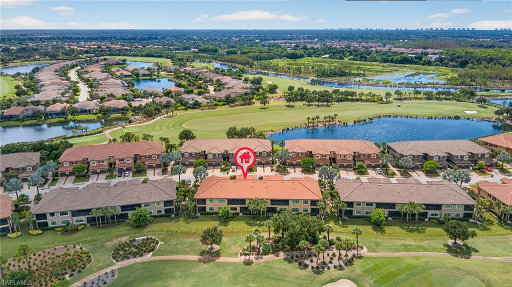 Aerial perspective of suburban area featuring a golf course and a nearby body of water