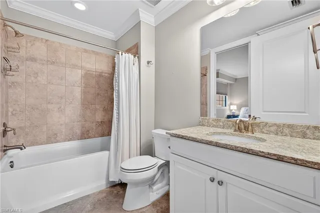a bathroom with a granite countertop sink toilet vanity mirror bathtub and shower