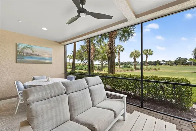 a living room with patio furniture and a floor to ceiling window